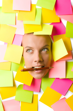 Woman with many reminder notes and pen in the mouth