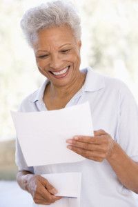 Woman reading letter smiling